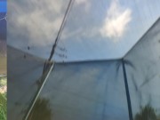 Tall girl in shorts jumping barefooted on a trampoline (slowed down) bottom view 13/16
