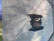 Tall girl in shorts jumping barefooted on a trampoline (slowed down) bottom view 2/16