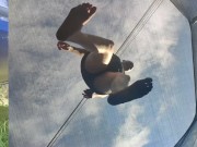Tall girl in shorts jumping barefooted on a trampoline (slowed down) bottom view 4/16