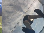 Tall girl in shorts jumping barefooted on a trampoline (slowed down) bottom view 5/16