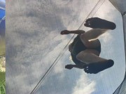 Tall girl in shorts jumping barefooted on a trampoline (slowed down) bottom view 6/16