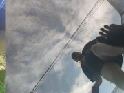 Tall girl in shorts jumping barefooted on a trampoline (slowed down) bottom view 8/16