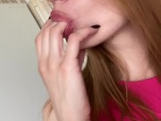 Pretty girl licking her fingers. 7/16