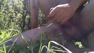 Naked young guy masturbates in nature