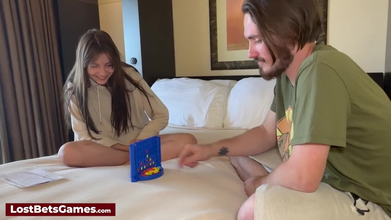 A couple playing a strip game on the bed when she loses to ...