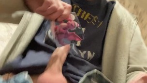 The guy plays with a dick, on a chair, cums on a T-shirt