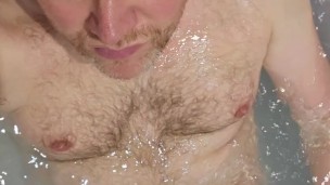 Uncut and naked in the bathtub while shaving my hair off.