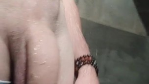 Je me masturbe sous la douche en short de bain et fait grossir ma grosse bite toute mouillée.