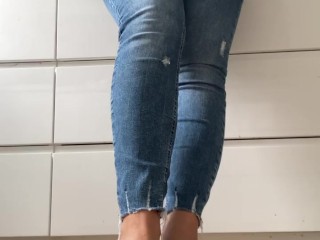 Woman in blue jeans and flip-flops in the kitchen do normal things and showing her feet barefoot