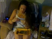 Busty girl in pink bra and panties smoking and playing video games