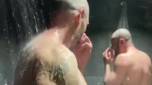Beefy men shower together in gym locker room