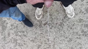 Friend is holding my cock while im peeing on the ground outdoor
