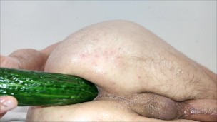 Close up cucumber insertion with massage oil and precum as lube