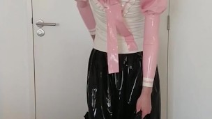 Putting on another long latex skirt over skirt, blouse, rubber stockings and panties, layers