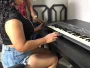 Una joven con curvas y una falda ajustada tomando su primera lección de teclado 2/16