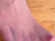 The girl in a gorgeous blue dress and beige stockings is putting on her stockings 14/16