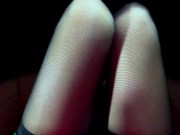 The girl lifts her skirt in the car and shows her black stockings